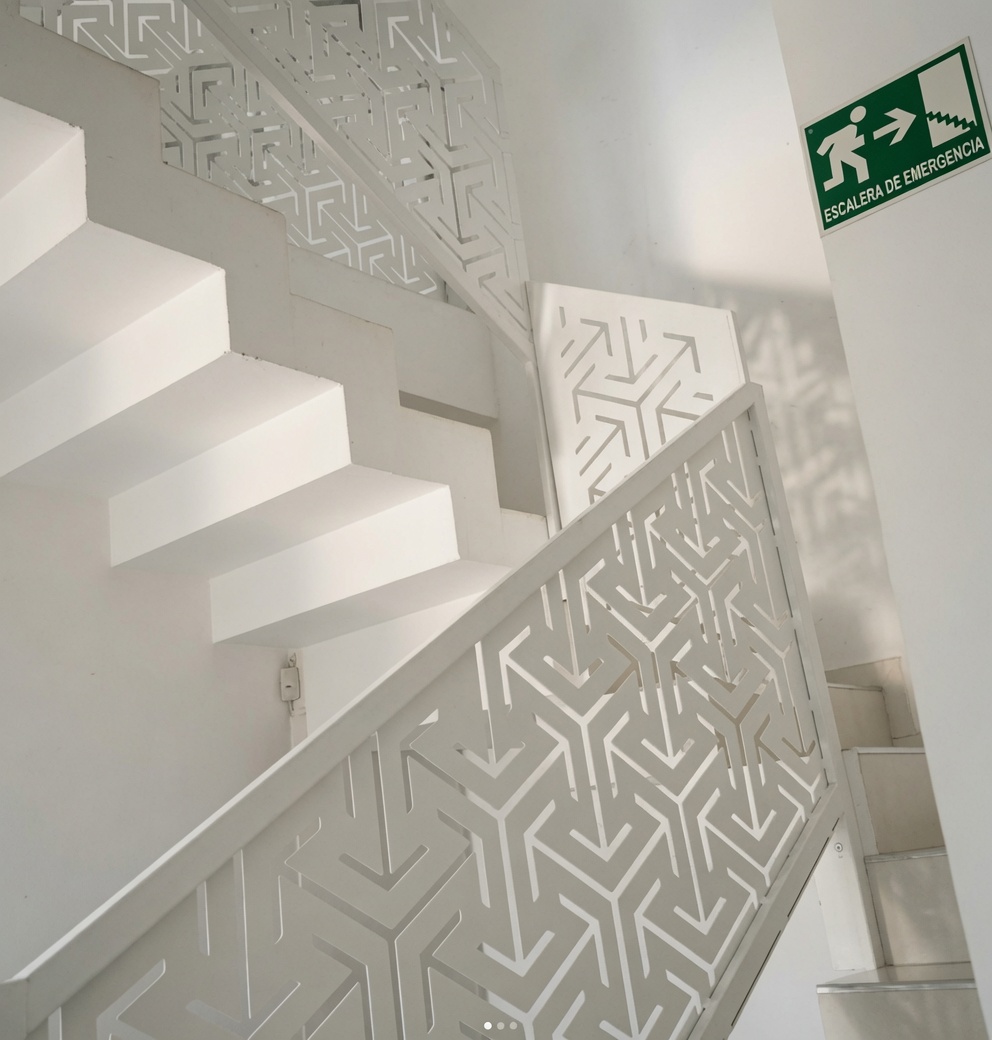 Escalera escultórica con baranda calada