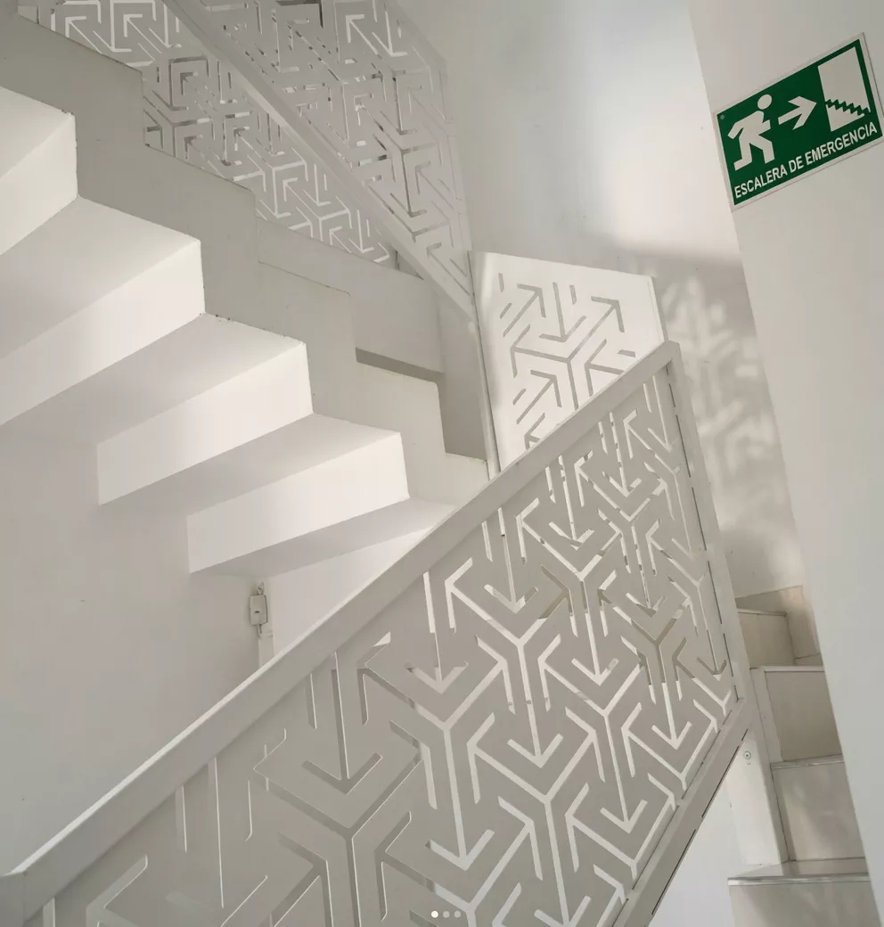 Escalera escultórica con baranda calada